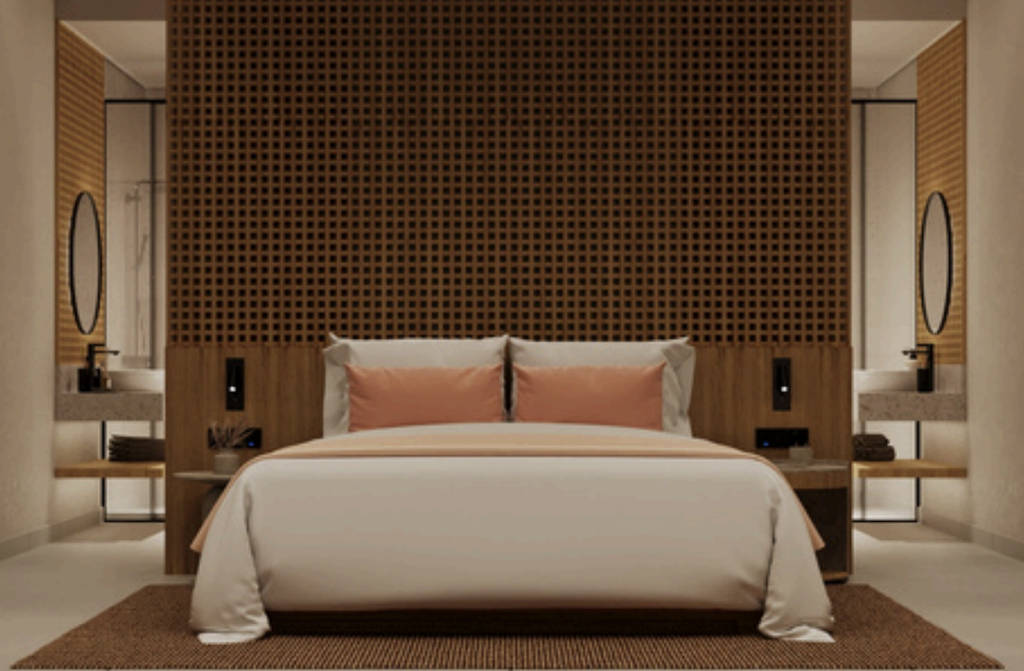 Moderní hotelový pokoj se dřevěnou akcentní stěnou a růžovými polštáři na posteli. - Moderní hotelový pokoj se dřevěnou akcentní stěnou a růžovými polštáři na posteli.