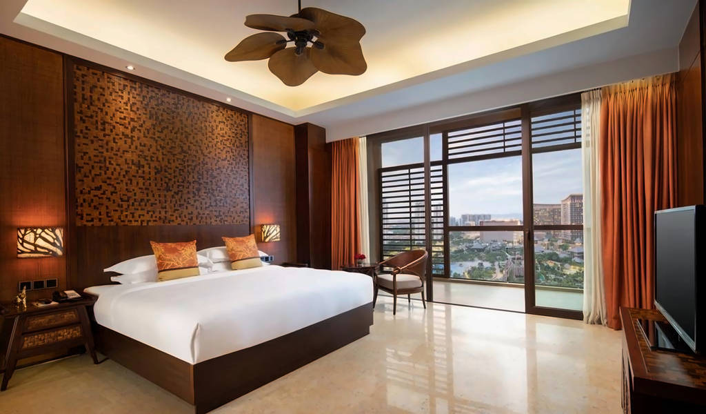 Moderní hotelový pokoj s manželskou postelí a velkými okny s výhledem na město. - Moderní hotelový pokoj s manželskou postelí a velkými okny s výhledem na město.