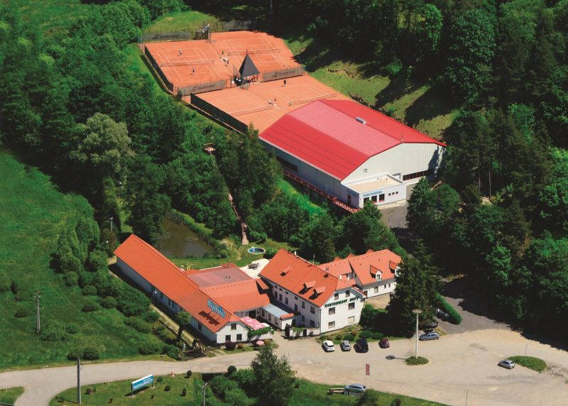 Areál hotelu s tenisovýmou halou a kurty.