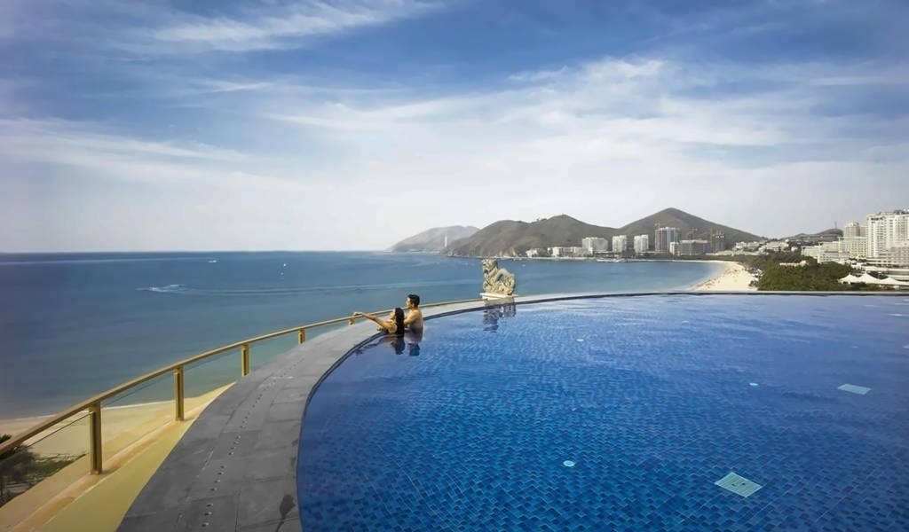 Nekonečný bazén s výhledem na oceán, pár si užívá výhled. - Nekonečný bazén s výhledem na oceán, pár si užívá výhled.