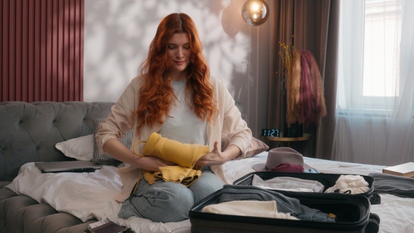 Kobieta pakuje ubrania do bagażu podręcznego